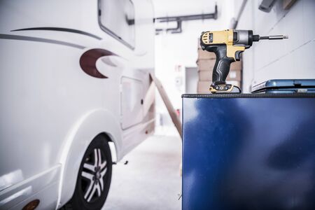 Camper Van RV Repair Concept. Recreational Vehicle in the Service Center. Drill Driver Power Tool.の写真素材