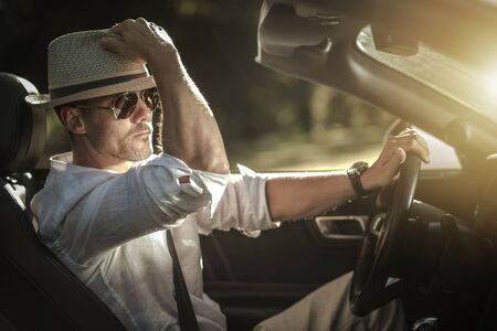 Summer Open Roof Road Trip. Caucasian Driver Wearing Stylish Hat and Sunglasses.の写真素材