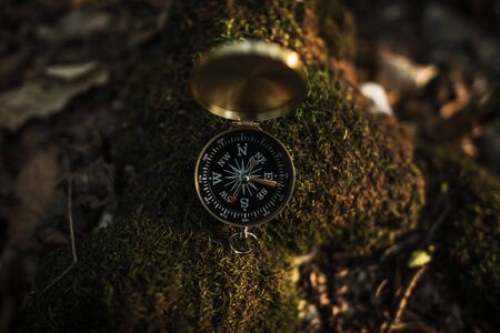Small Compass Device on Mossy Rock. Forest Hiking Theme. Necessary Equipment on a Trailhead.の写真素材