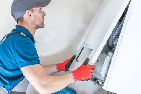 House Heating Unit Repair by Professional Technician. Closeup Photo. Home Equipment Issues.の写真素材