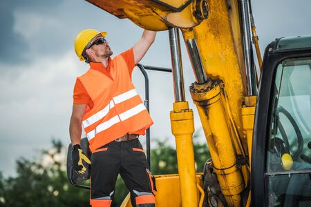 Modern Excavator Operator. Caucasian Construction Worker and the Industrial Machinery.の写真素材