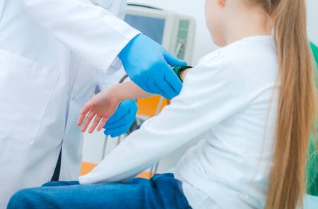 High Blood Pressure in Children. Seven Year Old Caucasian Girl and Doctors Office Examination. Healthcare Theme.の写真素材