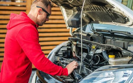Motorhome Engine Problem. Caucasian RV Camper Van Owner Looking Under the Hood.