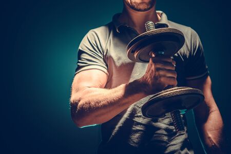 Dumbbells Home Exercise. Caucasian Men and His Everyday Workout. Body Building Theme.