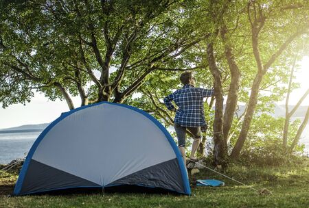 Woman in Her 60s on a Camping. Enjoying Sunny Morning in Front of Her Tent.の写真素材