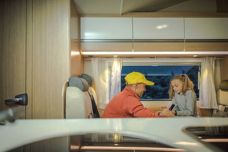 Family Time in RV Recreational Vehicle. Caucasian Men with His Daughter Playing Inside Camper Van.の写真素材