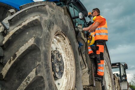 Road Construction Contractor. Caucasian Worker and the Heavy Duty Machine. 
