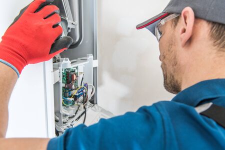 Technician Servicing Residential Heating Equipment. Central Heat Gas Furnace Issue. 

の写真素材
