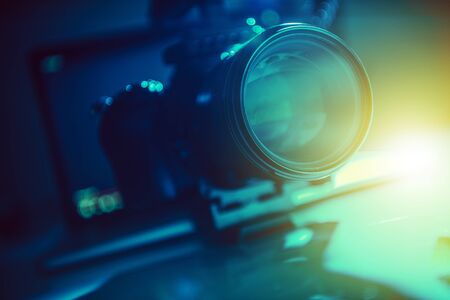Modern Video Production Equipment. Telephoto Lens Closeup Photo. Dark Blue and Greenish Theme....