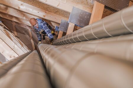 Residential Air Ventilation Pipeline Building. Worker Preparing Metal Air Vent Pipes.の写真素材