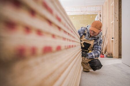 Male Craftsman Checking Stack Of Lumber For Home Improvement Project.の写真素材