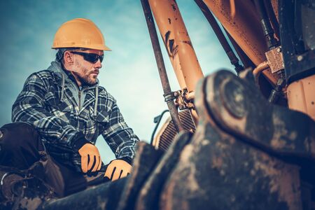 Close Up Of Male Construction Worker Checking Excavator Before Staring Job. 