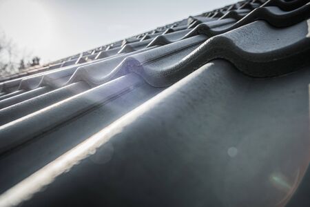 European Style Black Ceramic Roof Tiles Close Up Photo. House Roofing Theme.