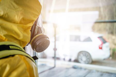 Men in Yellow Biochemical Hazmat Suite and Breathe Protection Mask Looking Outside the Window....