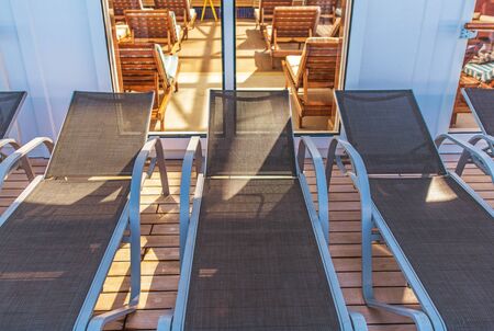 Rows Of Lounge Chairs In Indoor Swimming Pool Area And Outside On Patio. 