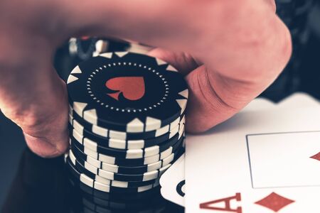 Close Up Of Man Holding Stack Of Poker Chips In Hand With Winning Cards On Table And Diamond Ace On...