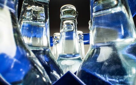 Close Up Of Blue Case Of Transparent Glass Bottles Filled With Mineral Water. の写真素材