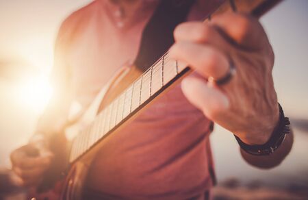 Close Up Of Male Rock And Roll Musician Playing Electric Guitar At Outdoor Concert. の写真素材