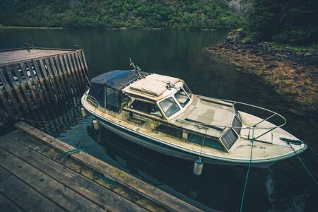 Aged and Dirty Boat and Wooden Dock Somewhere in South West Norway. Boating Theme.の写真素材