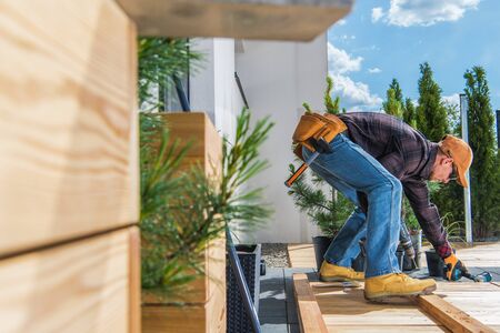 Industrial Theme. Home and Garden. Wooden Porch Building by Caucasian Men in His 30s During Sunny...