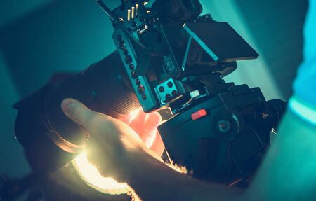 Professional Digital SLR Camera Operator with Equipment in His Hands. Videography and Motion Picture Production Equipment.の写真素材