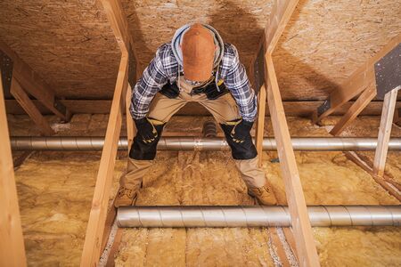 Ventilation Specialist Assembling Air Duct Pipe System In Attic Of New Construction Of Residential...