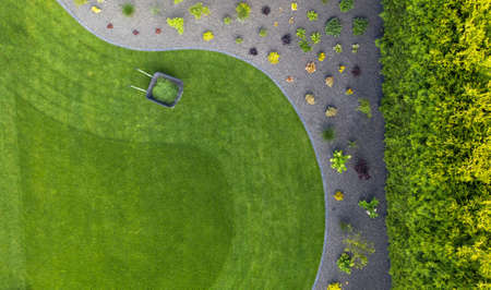 Aerial View of Taking Car of Residential Backyard Lawn. Grass Mowing in the Garden. Landscaping Industry.の写真素材