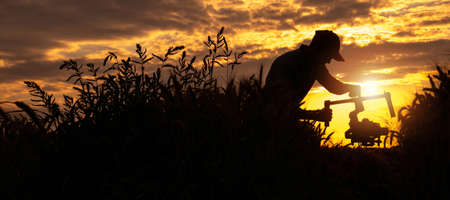 Video Operator with Modern Camera Installed on a Gimbal Walking Along Countryside During Scenic...