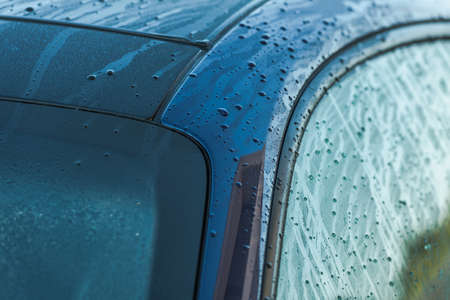 Automotive Industry. Clean and Wet Deep Blue Car Body Right After Pressure Washing Close Up. Cleaning Vehicle.の写真素材