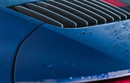 Close Up Of Back Of Blue Sports Car With Dropplets Of Water After Going Through Car Wash.の写真素材