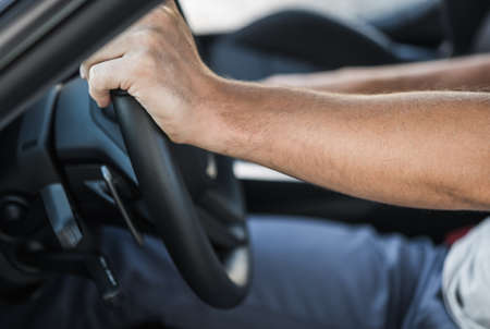 Caucasian Drivers Hands on the Car Steering Wheel Close Up. Automotive Industry Theme.