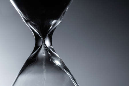 Contemporary Large Hourglass or Sandglass in a Dark Close Up. Old Times Timepiece Technology.の写真素材