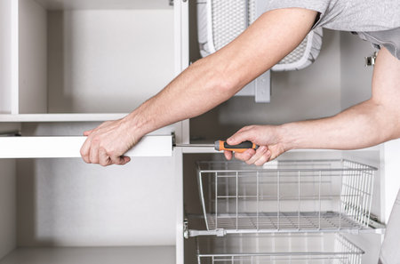 House Furnishing Theme. Apartment Closet Furniture Assembly Performed by Caucasian Worker in His 40s.の写真素材