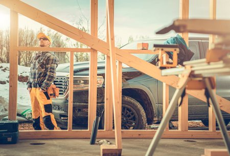 Caucasian Contractor Worker in His 40s. His Company Pickup Truck and the Construction Site. Men in...