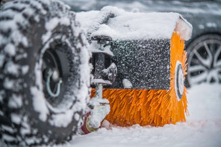 Gasoline Brush Broom Snow Removal Machine in Action During Heavy Snowfall. Winter Season Maintenance Machines.の写真素材