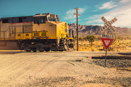 Southern California Mojave Desert Railroad Crossing in Rural Place. Cargo Train Engine. Railroad...