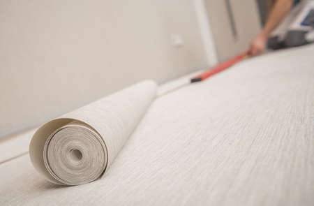 Roll of Modern Vinyl Wallpaper and Applying Preparation Inside Home Room.の写真素材