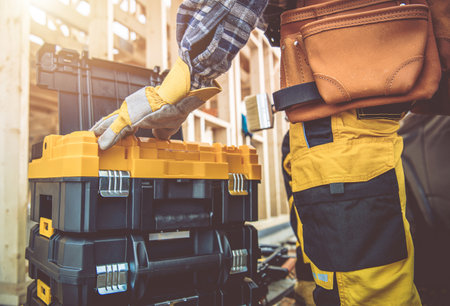Professional Construction Contractor Worker and His Tools Boxes. Preparing For Another Day in...