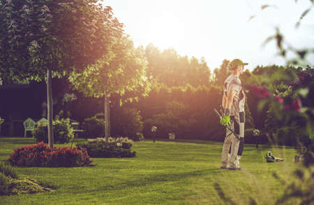 Caucasian Pro Gardener in His 40s Enjoying the Moment in His Clients Backyard Gardenの写真素材