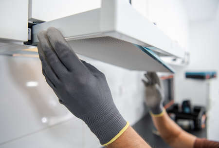 Kitchen Exhaust Fan Filter Replacement by Caucasian Worker. Stove Cooker Hood Filter.の写真素材