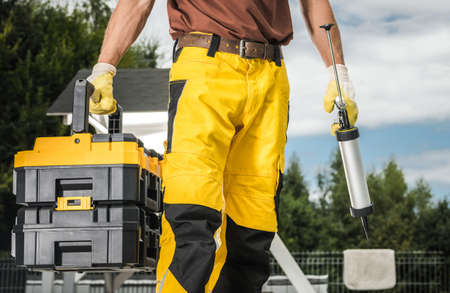 Caucasian Construction Worker with Silicon and Tools Box in His Hands Preparing To Do a Job. Industrial Theme.の写真素材