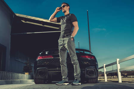 Successful Caucasian Men in His 40s Enjoying His Lifestyle While Staying Next to His Supercar....