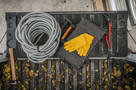 Electrician Tools and Materials on a Pickup Truck Bed Top View. Metal Electric Conduit and Tools...