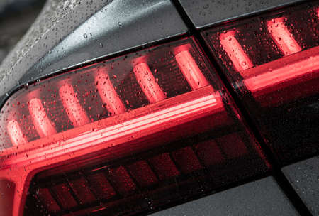 Modern Vehicle Wet From Car Washing Rear LED Light Close Up. Automotive Theme.