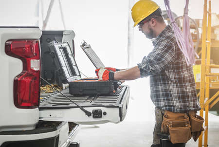 Caucasian Construction Worker Reading HVAC Assembly Plan and Documentation on a Site Next to His...