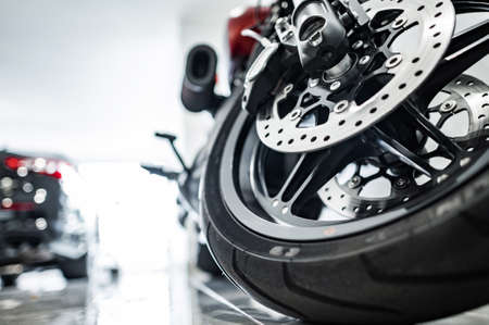 Modern Performance Motorcycle Inside Dealership Showroom. Front Wheel Close Up. Transportation...
