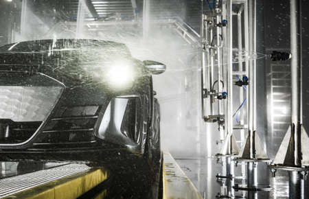 Vehicles Inside Modern Touchless Car Wash. Powerful Pressure Washing. Automotive and Transportation Technologies Theme.の写真素材