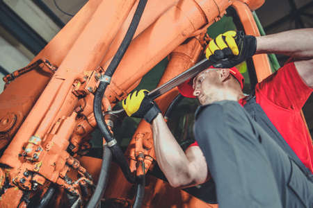 Heavy Construction Equipment Pneumatic Elements Replacement Performed by Caucasian Professional Mechanic. Broken Pneumatic Hose.の写真素材