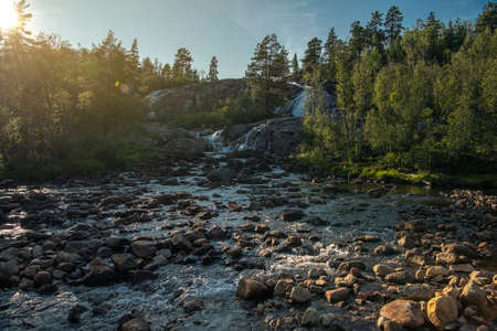 Scenic Norwegian Wilderness River with Rocky Bed. Scandinavian Summer Sunset Scenery. Norway,...