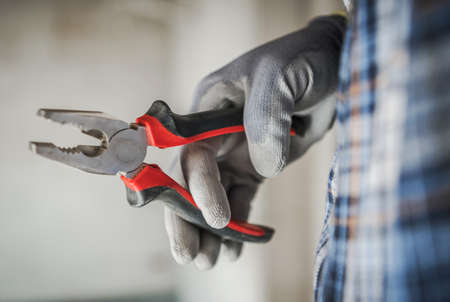 Construction Worker with Pliers in His Hand Close Up Industrial Themeの写真素材